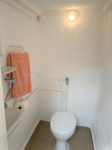a white bathroom with a toilet and a bath tub at Margó Vendégházak 2 in Hajdúszoboszló +11 photos