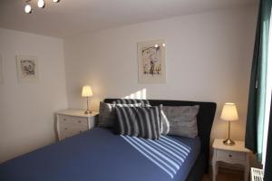 a bedroom with a blue bed with two night stands at Wohnung Julius 6 in Sankt Andreasberg +6 photos