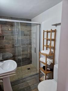 a bathroom with a glass shower and a sink at Apartamentos Wundermar in Torredembarra