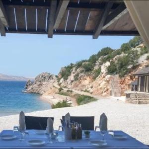 ein Tisch am Strand mit Blick auf das Meer in der Unterkunft Apartmani Sara Marija in Karlobag