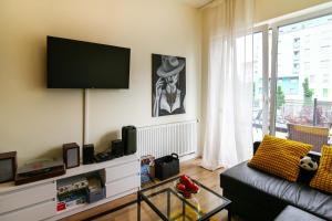 a living room with a couch and a flat screen tv at Apartament Królowej Nilu in Katowice