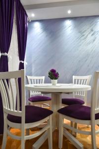 a dining room with a white table and chairs at Apartment Marijana in Vrnjačka Banja +3 photos