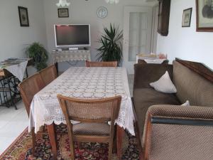 sala de estar con mesa con sillas y sofá en Ferienwohnung-STREUTALBLICK, en Fladungen