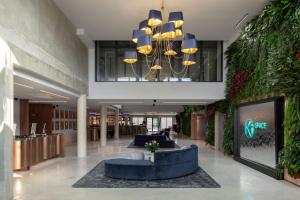 a lobby with couches and a chandelier in a building at Ki Space Hotel & Spa - près de Disneyland Paris in Serris