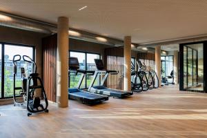 a gym with several treadmills and elliptical machines at Ki Space Hotel & Spa - près de Disneyland Paris in Serris