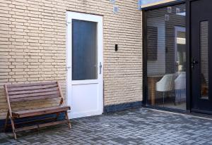 un banco de madera sentado frente a una puerta en The Suite Eindhoven by T&S, en Eindhoven