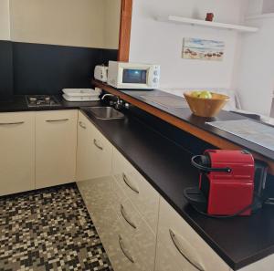 a kitchen with a red suitcase sitting on a counter at Apartamentos Wundermar in Torredembarra