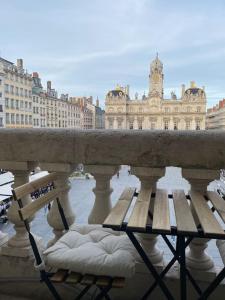 リヨンにあるGrand Balcon Place des Terreauxの建物のある橋の上に置かれたベンチ