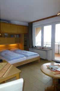 ein Schlafzimmer mit einem Bett und einem Tisch und einem Fenster in der Unterkunft Studio mit Meerblick auf die Robbenbänke von Norderney, geschützter Südwestbalkon in Baltrum