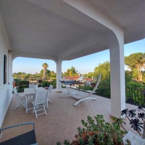 d'une terrasse avec des chaises blanches, une table et une clôture. dans l'établissement Casa Deborah, à Fontane Bianche