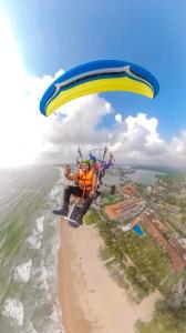 a man flying a parachute over a beach at Nade Villas Ahungalla in Ahungalla