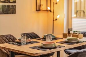 a wooden table with plates and bowls on top at Villa Verde - Nordhorn in Nordhorn