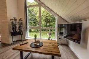 a living room with a table and a large window at Villa Verde - Nordhorn in Nordhorn