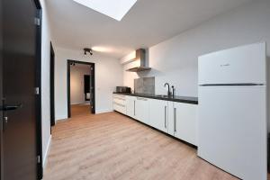 kuchnia z białymi szafkami i drewnianą podłogą w obiekcie The Vault - Eindhoven - by T&S w Eindhoven