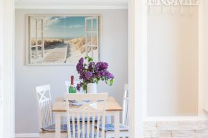 a dining room with a table and a picture of the beach at Uns Lütje Hus - Sellin in Sellin
