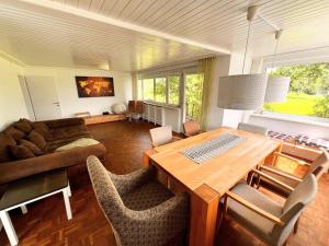 sala de estar con mesa de madera y sillas en Haus am Bodensee, en Fußach