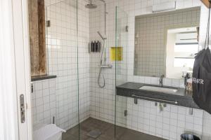 een badkamer met een douche, een wastafel en een spiegel bij Salt & Sill in Klädesholmen