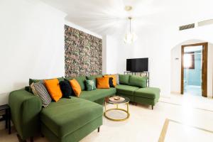un salon avec un canapé vert et une table dans l'établissement Wekey Homes Granada, El encanto de Navas Centro, à Grenade