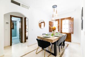 une salle à manger avec une table en bois et des chaises noires dans l'établissement Wekey Homes Granada, El encanto de Navas Centro, à Grenade