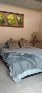 a bed with a blue blanket and pillows on it at Cabaña el amarillo in Barbosa