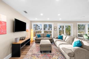 a living room with a couch and a tv at The Bay House-Bayfront serenity, stunning sunsets in Ward Ridge
