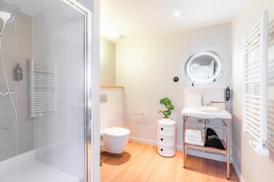 a bathroom with a shower and a toilet and a sink at Appart'City Collection Paris Vélizy in Vélizy-Villacoublay