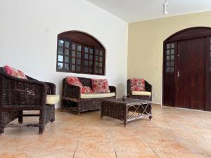 ein Wohnzimmer mit Korbstühlen und einem Tisch in der Unterkunft Casa agradável com piscina, ar condicionado e churrasqueira in Natal