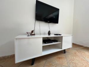 TV i/ili multimedijalni sistem u objektu Casa agradável com piscina, ar condicionado e churrasqueira