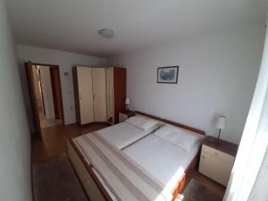 um pequeno quarto com uma cama e um armário em Ferienwohnung mit Meerblick von der Terrasse für bis zu sechs Personen em Trogir