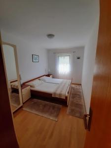 um quarto com uma cama e um espelho em Ferienwohnung mit Meerblick von der Terrasse für bis zu sechs Personen em Trogir