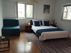 um quarto com uma cama e uma cadeira azul em Ferienwohnung mit Meerblick von der Terrasse für bis zu sechs Personen em Trogir