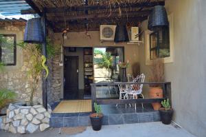 a porch of a house with a table and chairs at Foxy Crocodile Bush Retreat & Kruger Safari's in Marloth Park