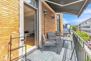 een balkon met stoelen en tafels op een gebouw bij Eat, Explore & Enjoy Downtown Montreal at this Sleek City Escape located in Plateau Mont-Royal - Apt 4 in Montreal