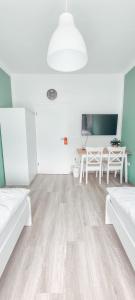 ein Wohnzimmer mit weißen Möbeln und einem Tisch in der Unterkunft Zweibettzimmer "Grün" in zentraler Lage in Bremen