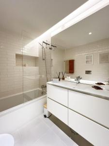 a white bathroom with a tub and a sink at Forte House T2 by Portugal Hideaway in Tavira