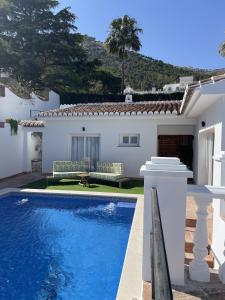 a villa with a swimming pool in front of a house at Villa Gracia in Mijas