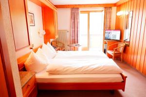 Postel nebo postele na pokoji v ubytování Hotel Christiania Saas-Fee