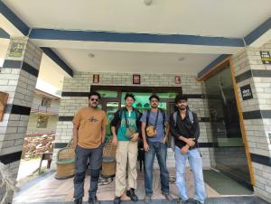 a group of men standing in front of a building at Triumph bed and breakfast and cafe in Kasol