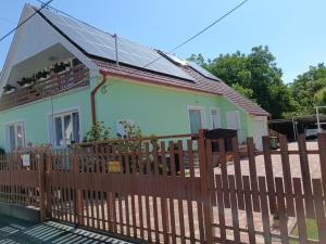 a house with a wooden fence in front of it at Margó Vendégházak in Hajdúszoboszló