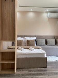 a bedroom with a large bed and a couch at Sky Apartman in Nyíregyháza