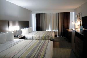um quarto de hotel com duas camas e uma secretária em Country Inn & Suites by Radisson, Council Bluffs, IA em Council Bluffs