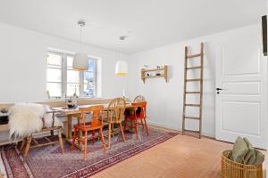 a dining room with a table and chairs and a ladder at Lovely Holiday Home In The Heart Of Løkken in Løkken +24 photos