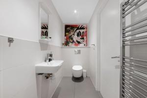 a white bathroom with a sink and a toilet at Manor House Studios By Morethanstays in London