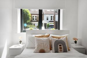a bedroom with a bed with a large window at Manor House Studios By Morethanstays in London
