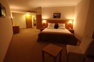 VelimeşeにあるShilla Hotelのベッドと椅子付きのホテルルーム