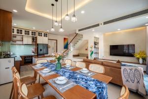 a kitchen and living room with a table and chairs at AnnA Villa - Novaworld Phan Thiết in Bình Tú