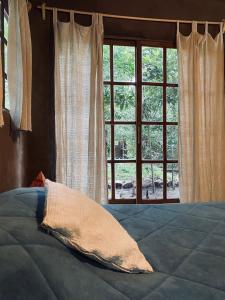 - un lit avec un oreiller en face d'une fenêtre dans l'établissement Eco cabaña Tierra Fértil, à Santa Ana