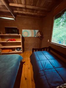 - une chambre avec un lit bleu et une fenêtre dans l'établissement Eco cabaña Tierra Fértil, à Santa Ana