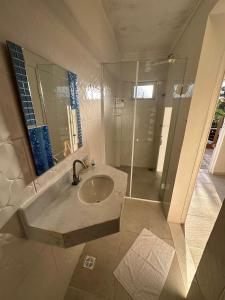 a bathroom with a sink and a shower at Mansão Tenório in Ubatuba
