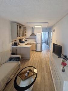 un salon avec un canapé et une cuisine dans l'établissement Valentinvtc location, au Cap d'Agde 2 autres photos